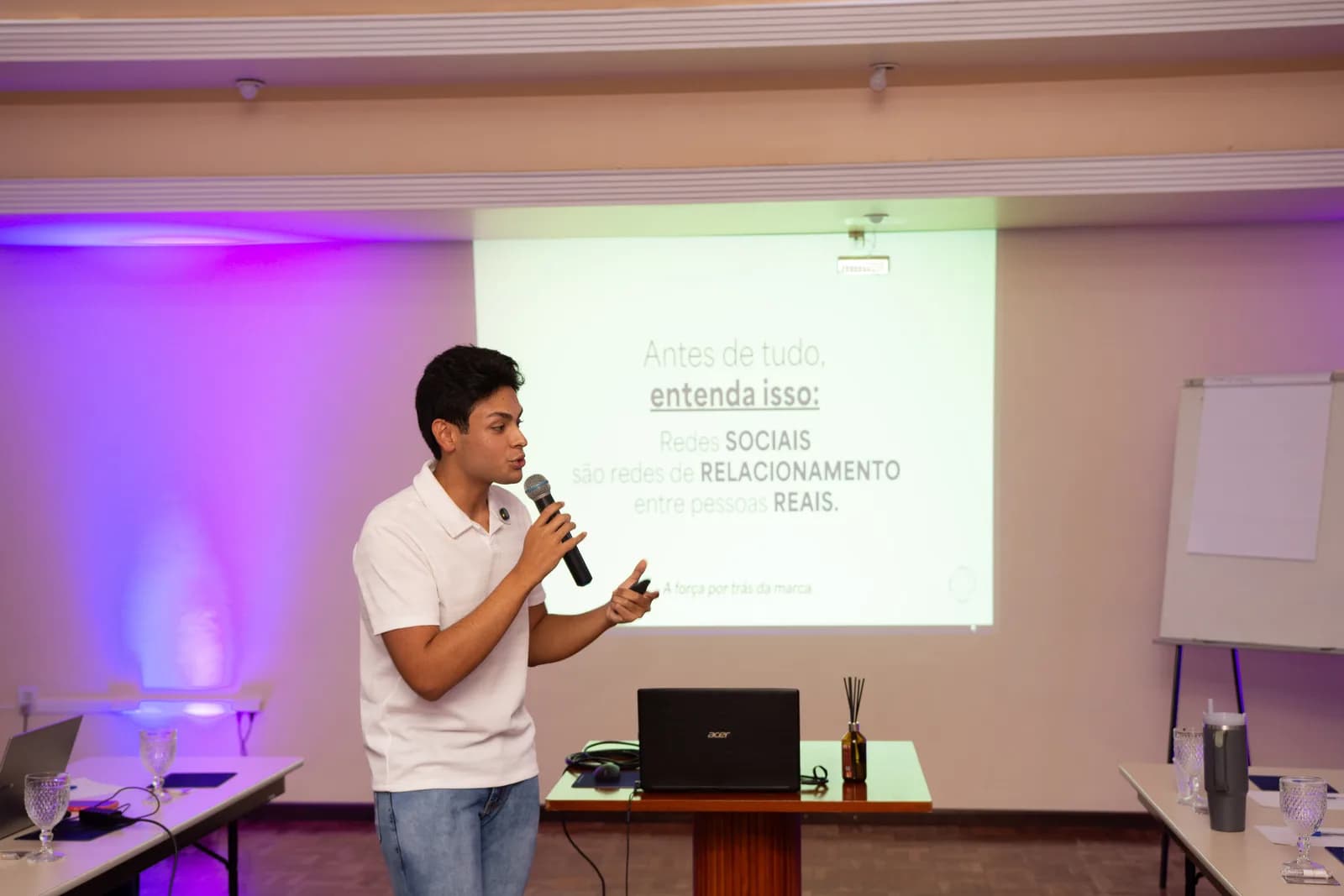 João Gabriel Sparrenberger, CEO da Liberty, palestrando de microfone na mão diante de um slide sobre redes sociais como redes de relacionamento